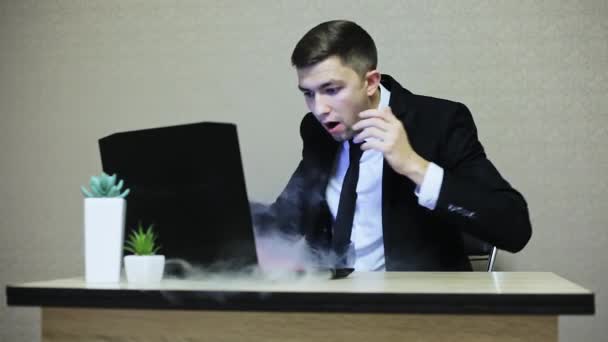 Businessman is shocked by laptop breakdown, smoke comes from computer - Metraje, vídeo