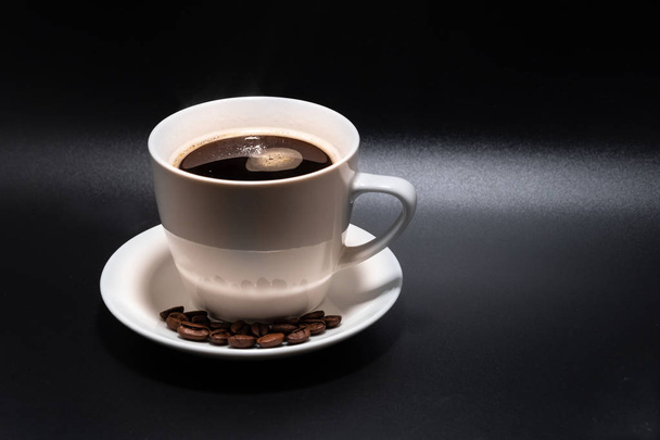 White cup and saucer with coffee on a black background 2018 - Photo, Image