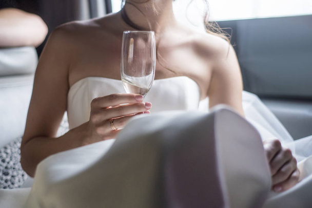 Wedding theme and style. Brides hands holding a glass of champagne. - Fotó, kép
