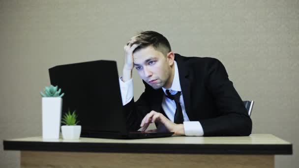 Втомився і нудний бізнесмен у костюмі, що працює на ноутбуці
 - Кадри, відео
