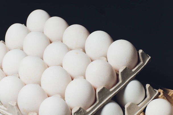 Several white eggs in an egg carton. - Фото, зображення