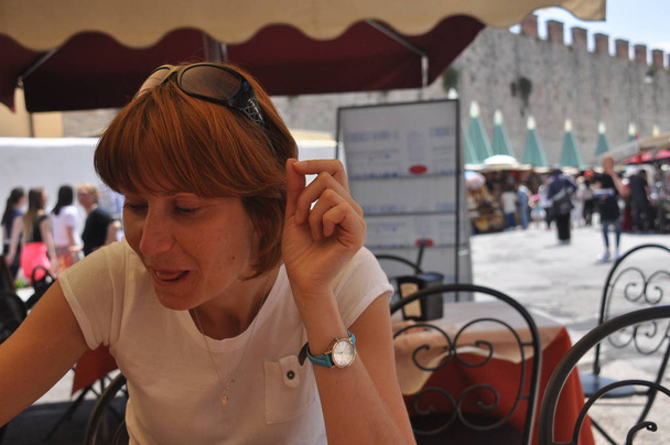 Piękna kobieta, degustacja mrożonej kawy w kawiarni w Pisa, Włochy. - Zdjęcie, obraz