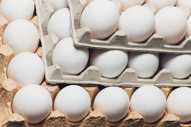 Several white eggs in an egg carton. - Fotó, kép