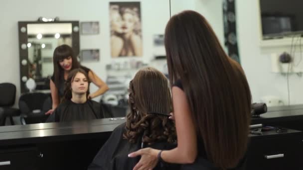Jeune femme au salon de coiffure se faire couper les cheveux par une coiffeuse
 - Séquence, vidéo