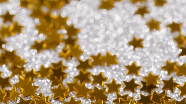 Sprankelende glitter in de vorm van een ster. Close-up op een zilveren achtergrond - Video