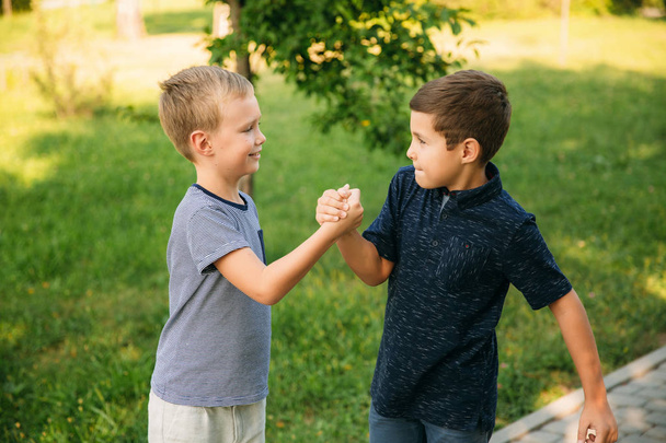 Δύο αγόρια τους φίλους περνούν χρόνο σε πάρκο. Παιδικά μοντέλα - Φωτογραφία, εικόνα