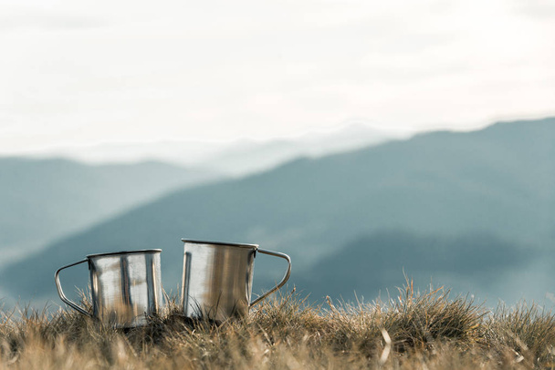 металеві чашки на фоні гір
 - Фото, зображення
