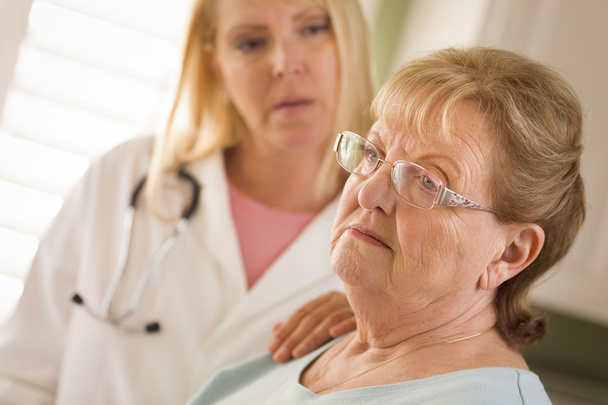 Senior Adult Woman Being Consoled by Female Doctor or Nurse - Foto, immagini