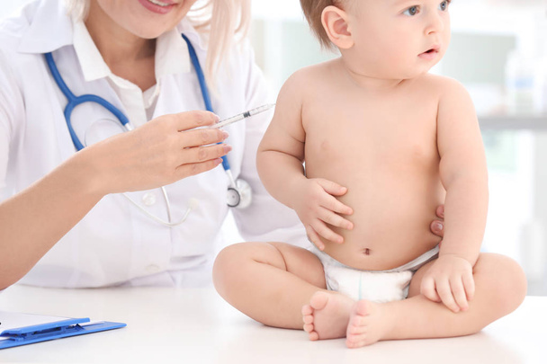 Female doctor vaccinating baby boy in clinic - Fotografie, Obrázek