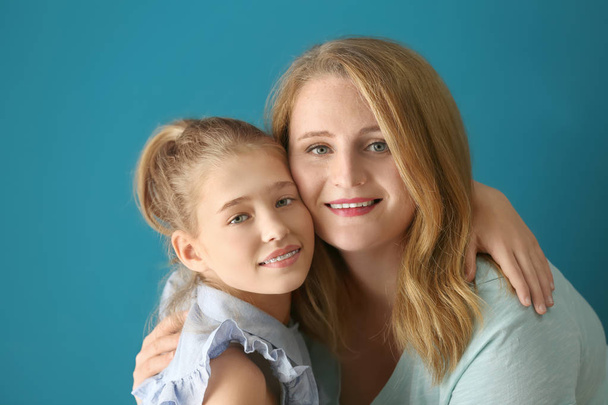 Portrait of happy mother and daughter on color background - Foto, Imagen