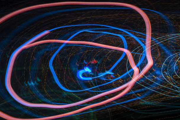 Modelli a spirale astratti luminosi da strisce luminose colorate su uno sfondo nero
 - Foto, immagini