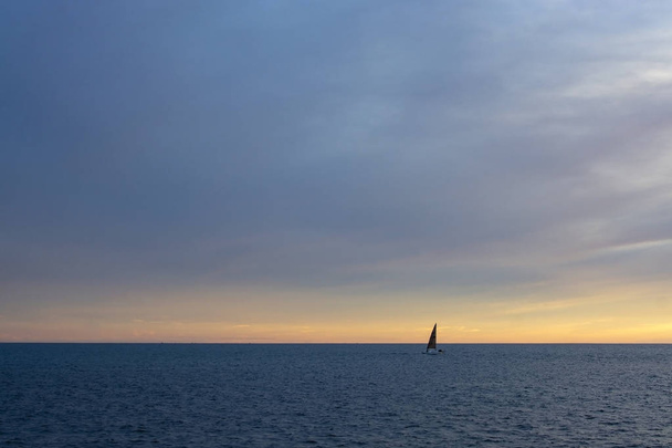 Rovný horizont linie s plachetnici nad Středozemním mořem v růžové a modré v listopadu v Mallorca, Španělsko. - Fotografie, Obrázek