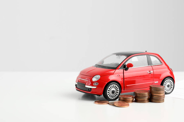 Toy car and money on white background, space for text. Vehicle insurance - Fotografie, Obrázek