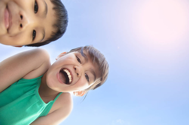 日光の下で幸せな男の子と女の子顔をクローズ アップ - 写真・画像