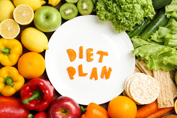 Flat lay composition with healthy food and words "DIET PLAN" on plate. Concept of weight loss - Zdjęcie, obraz
