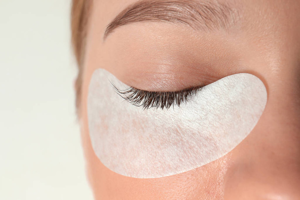 Young woman undergoing eyelash extension procedure, closeup - Foto, Imagen
