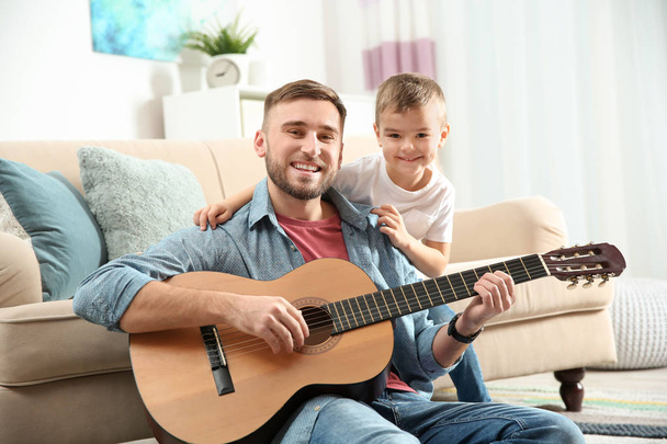 Father playing guitar for his son at home - Fotoğraf, Görsel