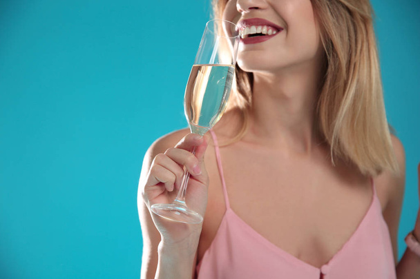 Beautiful woman with glass of champagne on color background, closeup. Space for text - Fotó, kép