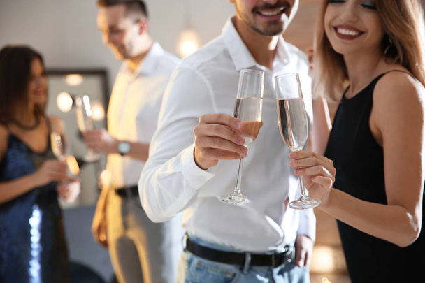 Casal copos clinking com champanhe na festa dentro de casa, close-up
 - Foto, Imagem