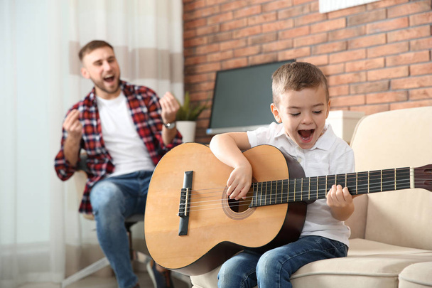 Father and son playing guitar and singing at home - Fotoğraf, Görsel