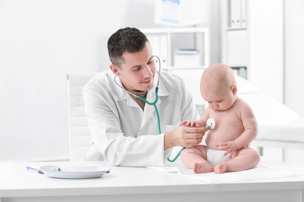 Children's doctor examining baby with stethoscope in hospital - Foto, Imagen