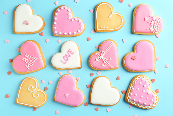 Composition with decorated heart shaped cookies on color background, top view. Valentine's day treat - Foto, afbeelding