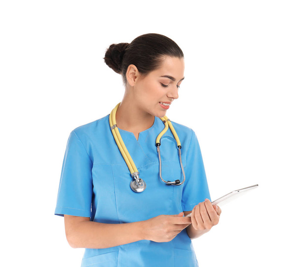Portrait of young medical assistant with stethoscope and tablet on white background - Photo, Image