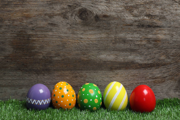Decorated Easter eggs on green grass. Space for text - Φωτογραφία, εικόνα