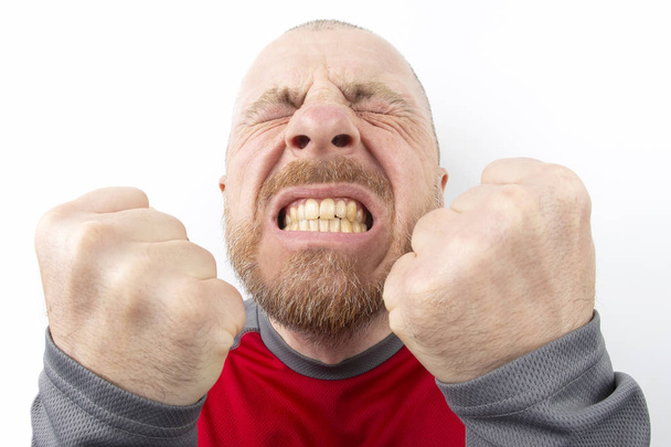 Homem barbudo com emoções fortes e com punhos cerrados fechar-se no backgroun branco
 - Foto, Imagem