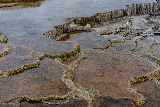 El agua gotea sobre escalones de roca volcánica en Yellowstone
 - Foto, imagen