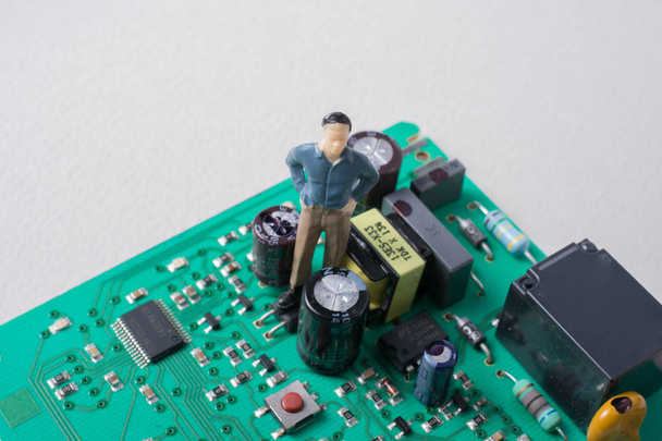 電子機器の回路基板上の男性モデルの小さな置物 - 写真・画像