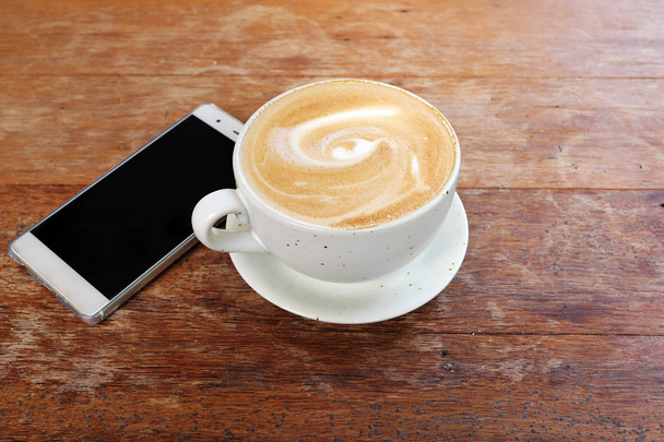 Ahşap bir masa üzerinde sıcak latte - Fotoğraf, Görsel