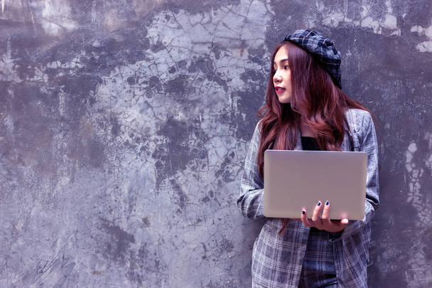 Γοητευτικό όμορφο νεαρή εργαζόμενη γυναίκα κρατώντας το laptop και βλέπουν αντίγραφο χώρου. Ελκυστικές όμορφο κορίτσι χρησιμοποιούν φορητό υπολογιστή και internet online για εργασία ή την επικοινωνία πελάτη σε εξωτερικούς χώρους. - Φωτογραφία, εικόνα