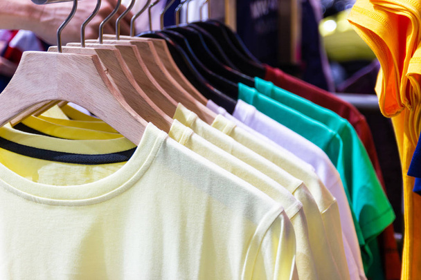 T-shirt colorida em cabides para venda em lojas de departamento
. - Foto, Imagem