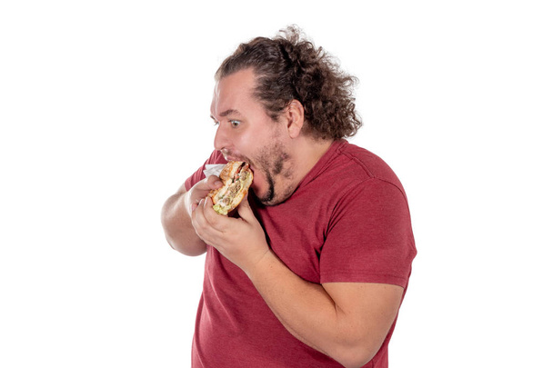 Funny fat man eating hamburger. Fast food, unhealty eat - Фото, зображення