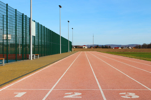 Red treadmill at the stadium. Element of a sports complex. Outdoor coating for sports. A place for competitions in athletics. 1, 2, 3 - start track numbers - Photo, Image