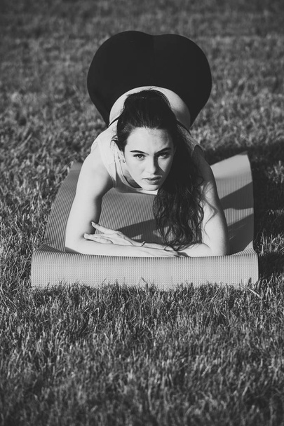 Fitness donna con coda di cavallo facendo posizione tavola su erba verde
 - Foto, immagini