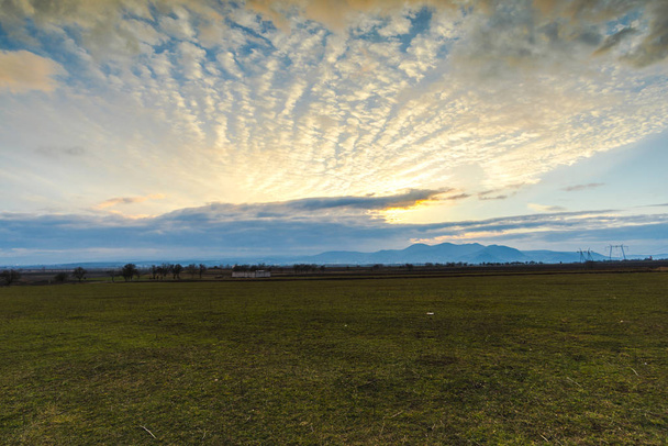 Vue pittoresque au champ de printemps le soir avec des nuages colorés
 - Photo, image