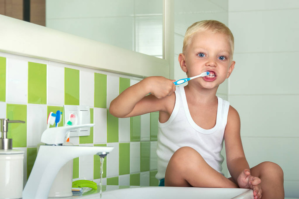 Small boy brushing teeth in the bathroom.The beginning of a new day - Foto, immagini