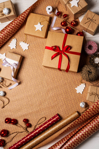 Top view of gift boxes, packing tapes, rope, paper rolls and decorations props on wrapping paper - 写真・画像