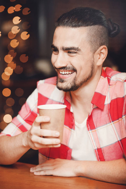 Man drinking paper cup of coffee in cafe. Morning christmas concept - Zdjęcie, obraz
