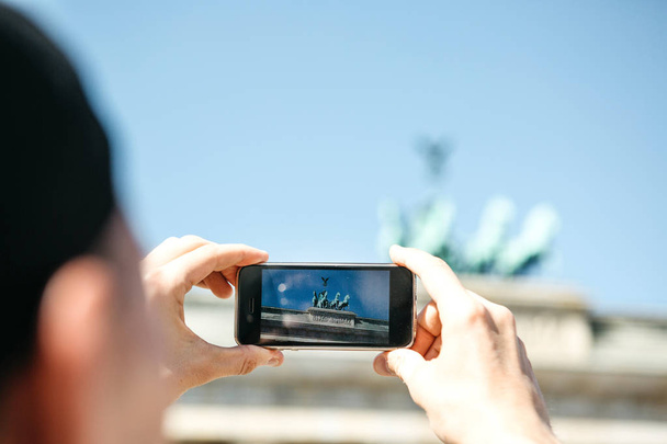 Fotografías turísticas en un teléfono móvil de la Puerta de Brandeburgo en Berlín en Alemania. Visitar lugares turísticos
. - Foto, Imagen