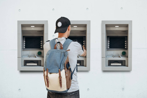 El turista retira dinero del cajero automático para otros viajes. - Foto, imagen