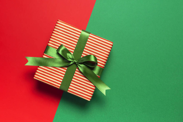 Geschenkboxen mit grünem Band auf rot-grünem Hintergrund von oben flach gelegt. Urlaubskonzept, Neujahr Weihnachtsgeschenk, Geschenke Geburtstag Valentinstag Weihnachten Glückwünsche festlich Hintergrund Kopierraum - Foto, Bild