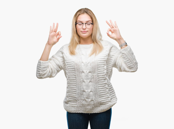 Mujer caucásica joven con gafas sobre fondo aislado relajarse y sonreír con los ojos cerrados haciendo gesto de meditación con los dedos. Concepto de yoga
. - Foto, Imagen