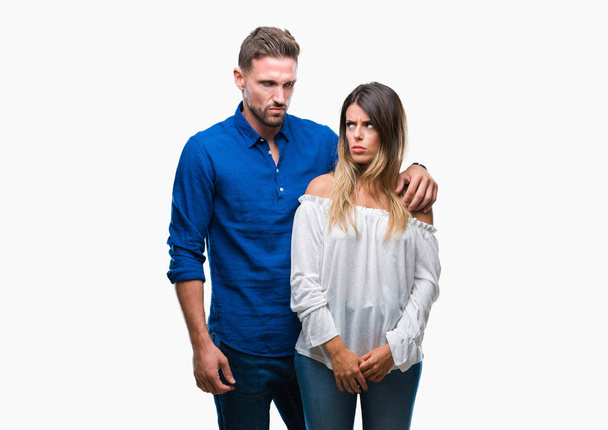 Young couple in love over isolated background skeptic and nervous, frowning upset because of problem. Negative person. - Photo, Image