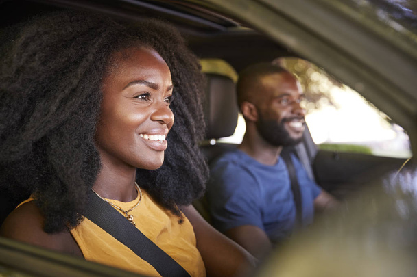 junges schwarzes Paar lächelt während Autofahrt - Foto, Bild