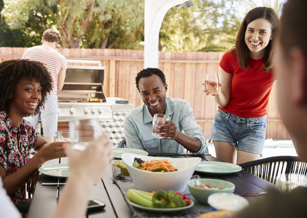 Young adult friends sitting outdoors and barbecuing - Fotoğraf, Görsel