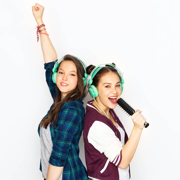 teenage girls in earphones listening to music - Фото, зображення
