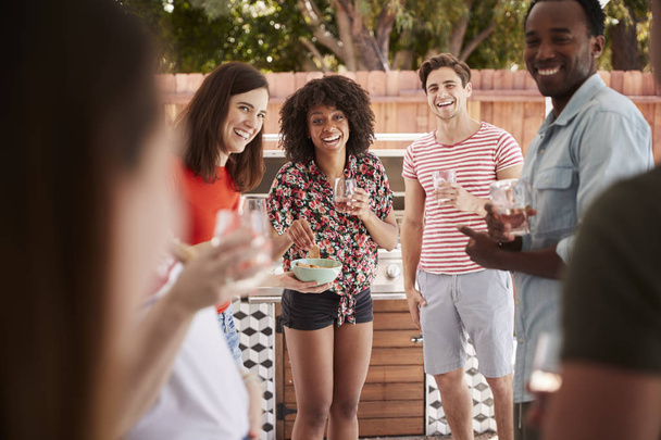 Young adult friends standing with drinks at a backyard party - Foto, Imagem